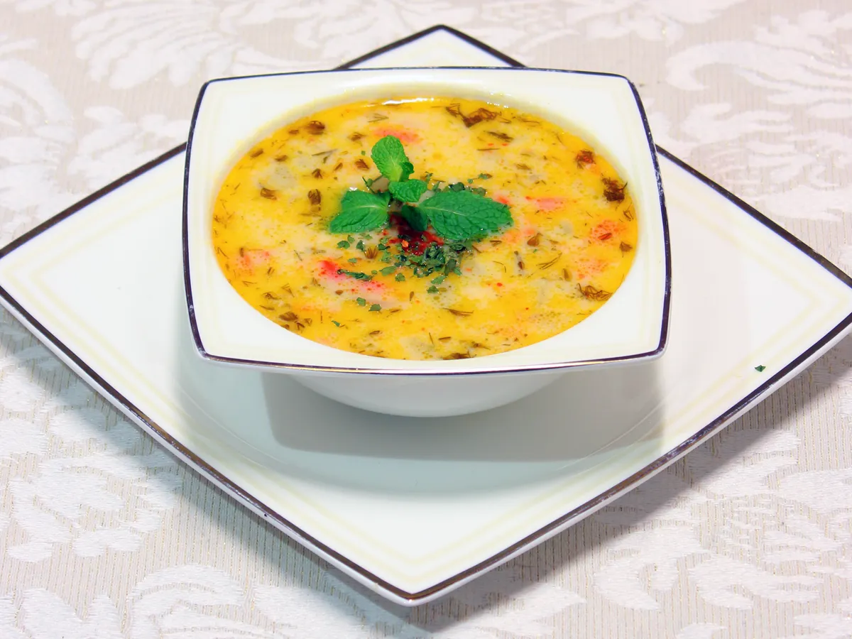 Gemüsesuppe mit Kräutern und Minze in einer weissen Schale